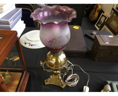 A brass table lamp with pink glass frosted shade.