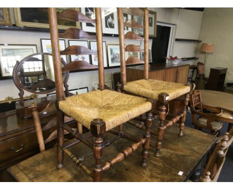 A set of six walnut farmhouse style dining chairs with rush seats and ladder backs.