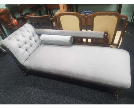 the button upholstered chaise with a carved oak frame on turned supports with ceramic castors 