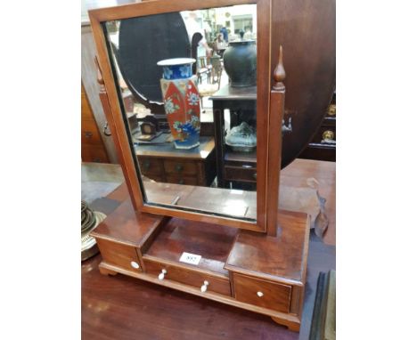 the rectangular beveled glass plate contained within a mahogany frame on an inverted base fitted with drawers and terminating