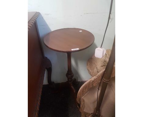 the circular top above a single pillar support on a tripod base 
