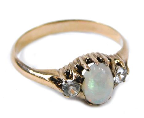 A three stone dress ring, the central set with oval opal, in claw setting, flanked by two illusion set diamonds, on rose gold