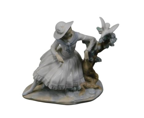 A Nao figure of a lady perched near dove on branch, stamp to underside, 25cm high. 