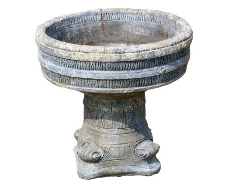 A reconstituted stone garden planter, the barrel top on a trifold base, 57cm high, 65cm wide. (AF)