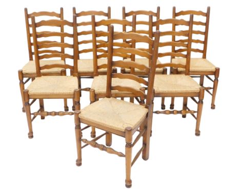 A set of eight oak ladder back dining chairs, each with a rush seat, 290cm long, one leaf of a later date, etc. (AF)