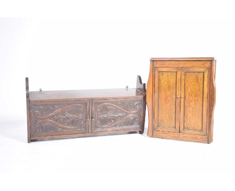 Two late 19th early 20th Century oak wall cupboardsThe first with a pair of stylized leaf carved doors with brass droplet han