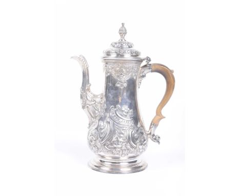 A George II silver coffee potOf baluster form, profusely embossed with scroll and foliate decoration, the domed hinged lid wi