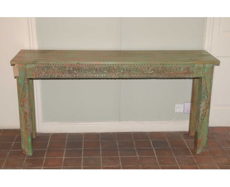 A rustic hardwood painted console tableThe rectangular plank top above a heavily carved frieze raised upon two substantial fr