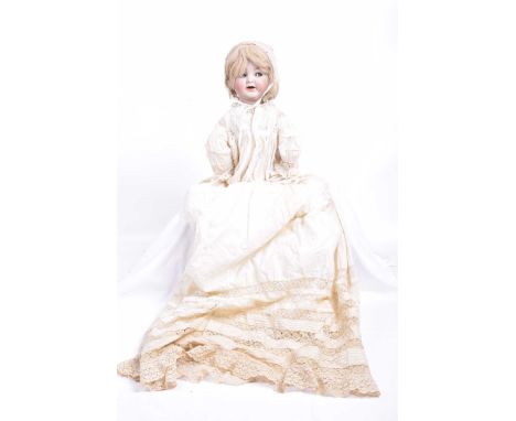 A German bisque headed dollWith blonde wig, blue eyes with sideways movement, open mouth with tongue, impressed marks K*R Sim