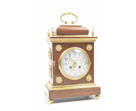 A reproduction mahogany cased bracket clockHaving gilt brass mounts and swing handle, the painted dial having Arabic numerals