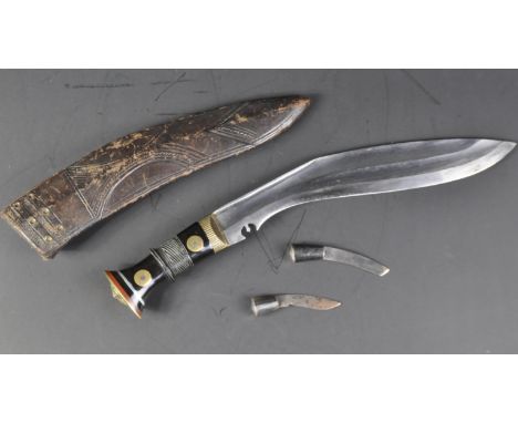 A vintage Nepalese / Gurkha Regiment Kukri knife dagger. The knife having a brass capped pommel with diamond shaped lozenge a