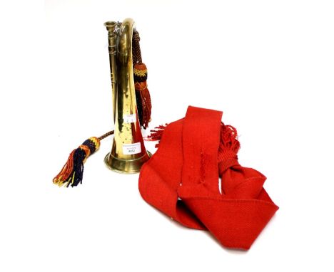 Military Bugle in brass, no makers marks, complete with decorative cords. Also a red Staff Sgt's sash.