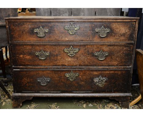 A George III oak chest of drawers, fitted with three long drawers, retaining original handles, raised on bracket feet