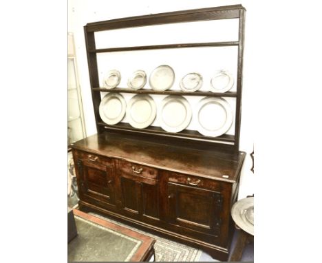 A George II oak dresser and rack, the rack possibly associated, the rack with three plate shelves, the base section with a si