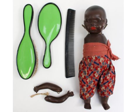 A German porcelain Heubach Koppel black doll, modelled as an African child in native dress and an Art Deco cased mirror, brus