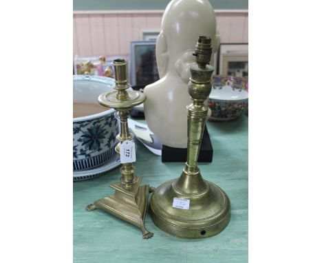 A large antique Dutch brass candlestick with circular drip tray, knopped and baluster stem and trifoil base with claw feel, 1