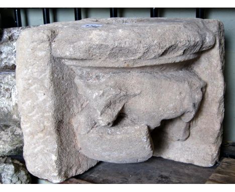 An antique possibly early reclaimed carved natural stone corbel/corner stone with bull and shield detail, 28 cm high x 30 cm 