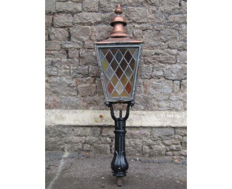 A Victorian street lantern the copper square tapered hood with raised finial and enclosed by possibly later associated leaded