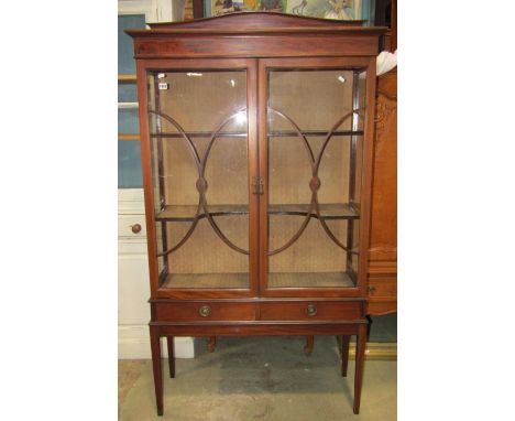 An inlaid Edwardian mahogany display cabinet with chequered stringing, freestanding and enclosed by a pair of rectangular gla