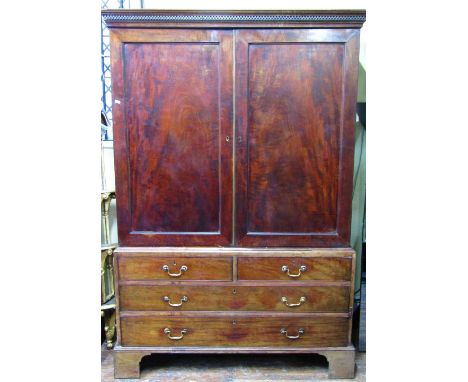 A Georgian mahogany linen press with moulded and dentil cornice over a pair of rectangular moulded panelled doors with well m
