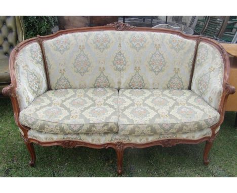 A French parlour room sofa with well carved and moulded show wood frame, raised on cabriole supports, with repeating floral a