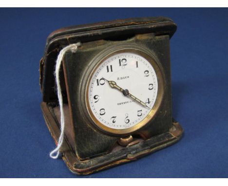 Tiffany &amp; Co eight day folding travel clock within a leather case, the 4 cm enamel dial with Arabic numerals and set with