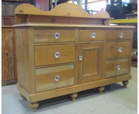 A Victorian stripped pine Lancashire dresser, the shallow raised and shaped back supporting a narrow shelf over an arrangemen