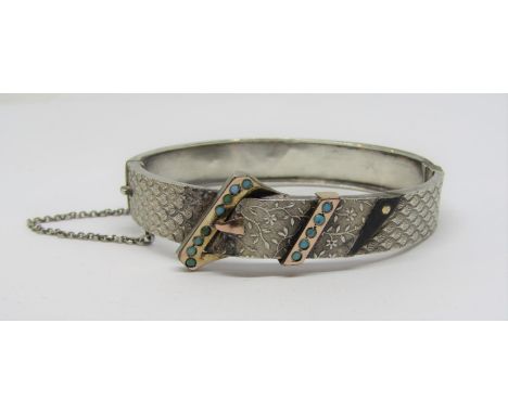 Aesthetic movement hinged bangle in the form of a buckled belt, with turquoise cabochons and gold highlights, in unmarked whi