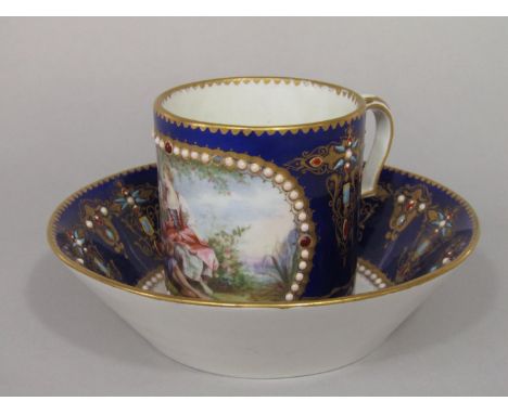 An 18th century Sevres blue ground cabinet cup and saucer with central Watteauesque style painted panel to the cup, within en