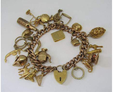 Good 9ct curb link charm bracelet with heart padlock clasp, hung with twenty four novelty charms, most stamped '375', to incl