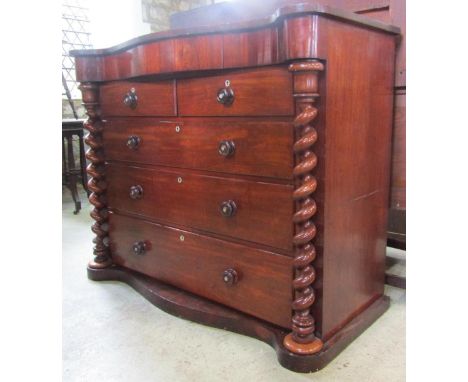 A Victorian mahogany bedroom chest with serpentine frieze enclosing a central over a flat fronted chest of two short over thr