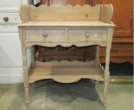 A 19th century stripped pine wash stand with raised three quarter shaped gallery, over two frieze drawers with turned support