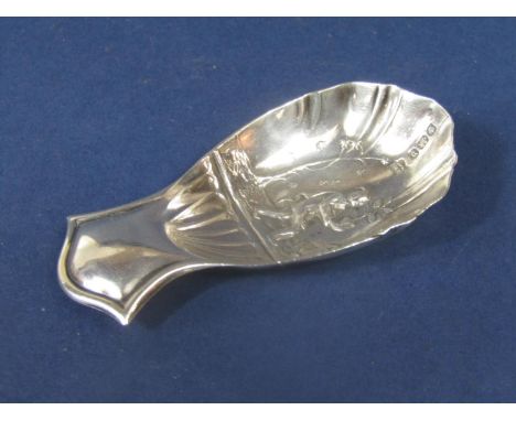 A good quality early 20th century silver caddy spoon, the scalloped bowl embossed with a tea picker, with a tree and cottage 