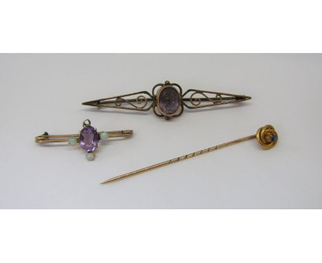 Group of antique gold jewellery comprising a 15ct stick pin with blue spinel knot terminal, a 9ct amethyst and opal brooch of