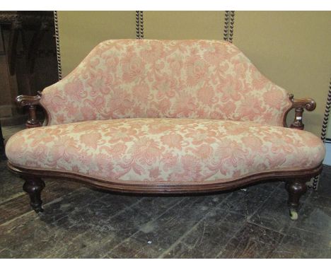 A Victorian drawing room sofa of small proportions, with carved walnut show wood frame, the shaped seat and back set within s