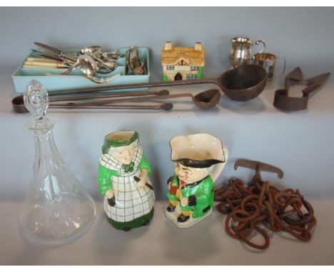 A box of interesting items to include various silver plated flatware, iron work ladle and further kitchenalia, two toby jugs,