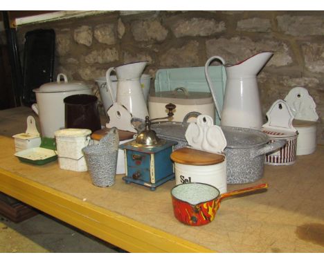 A quantity of mainly vintage enamel ware, English and continental including cylindrical flower bin, large jugs, various wall 