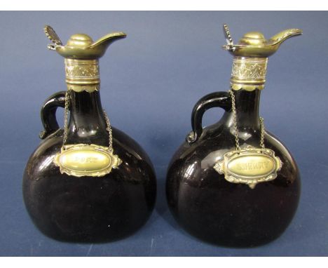 A pair of antique brown glass flask decanters with silver plated lids and scallop shell thumb piece with sherry and port deca