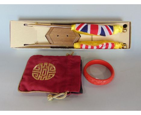 A pair of miniature desk top American flags on hard wood base, together with a Cinnabar type bangle 