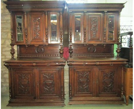 A pair of 19th century oak two sectional buffets, the upper enclosed by three panelled doors, two with bevelled edge plates, 