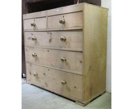 A 19th century stripped pine caddy top bedroom chest of two short over three long graduated drawers with later polished brass
