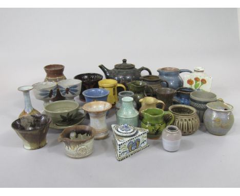 A quantity of studio pottery wares of various design including a tea pot with slip decoration, various jugs, vases, a bottle 