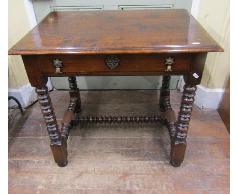 A good quality oak side table in the 17th century manner, the plank top with moulded outline over a frieze drawer raised on f