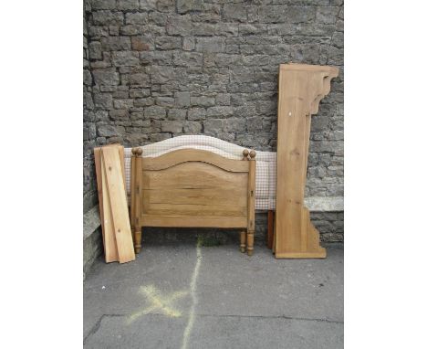 A continental stripped and waxed pine single bedstead, the panelled and arched head and foot boards flanked by octagonal turn