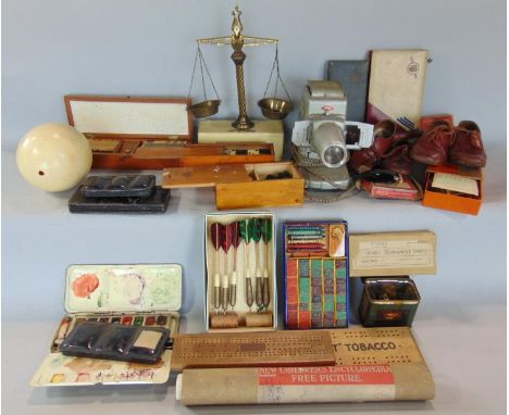 A box of interesting items comprising various gaming items, darts, etc, set of postal scales, dolls shoes, paints, ostrich eg