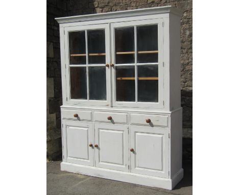 A pine two sectional kitchen dresser with painted and distressed finish, enclosed by a pair of segmented glazed panelled door