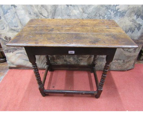 A Georgian oak side/occasional table, the overhanging rectangular planked top raised on four turned bobbin legs united by mou