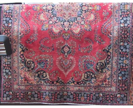 A Persian Mashad with various floral panels and medallions upon a light red ground, 270 x 180cm 