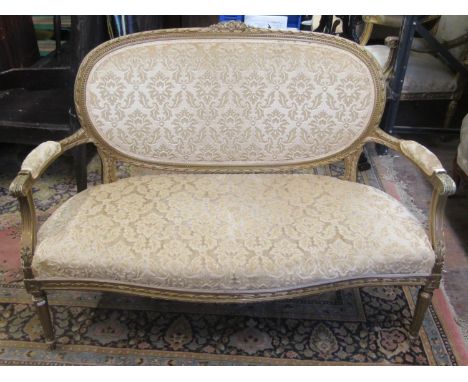 A late 19th century parlour room sofa, with carved and painted framework, with repeating geometric detail, acanthus and other