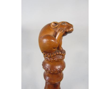 A good carved Japanese simulated bamboo fruit wood walking stick, mounted by a carved rat knop and stick covered in various f